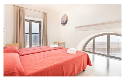 Habitación doble con ventanal frontal y vistas al paseo marítimo