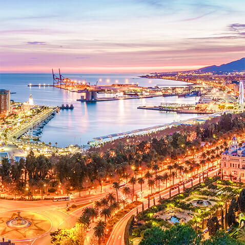 Vista aérea de Málaga por la noche, con las calles y el puerto iluminados