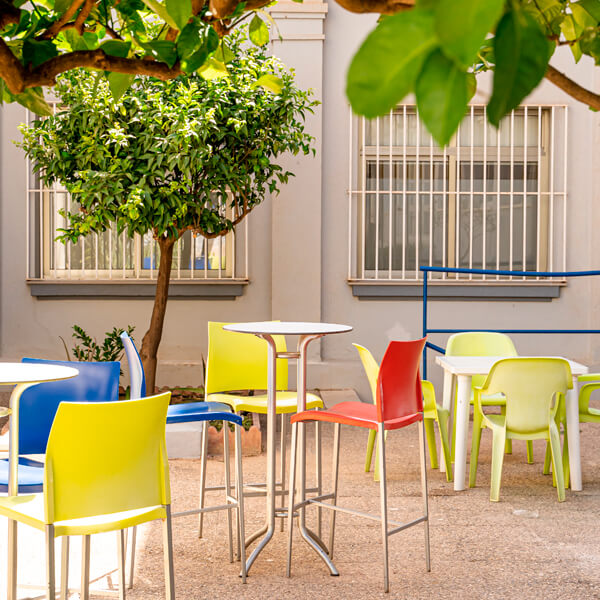 Patio interior con toldo, sombra, árboles y zona de descanso.