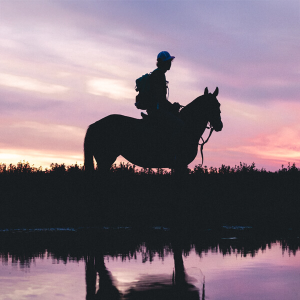 Chico montando a caballo al atardecer en la campiña cordobesa