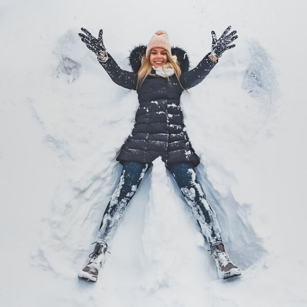 Chica haciendo un ángel en la nieve