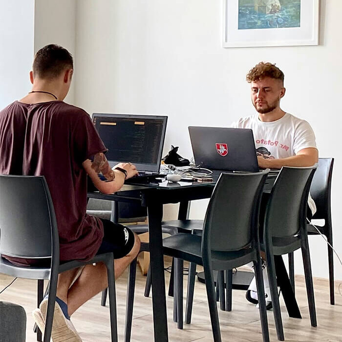 Dis chicos j&oacute;venes, con sus port&aacute;tiles en la sala de estudios.
